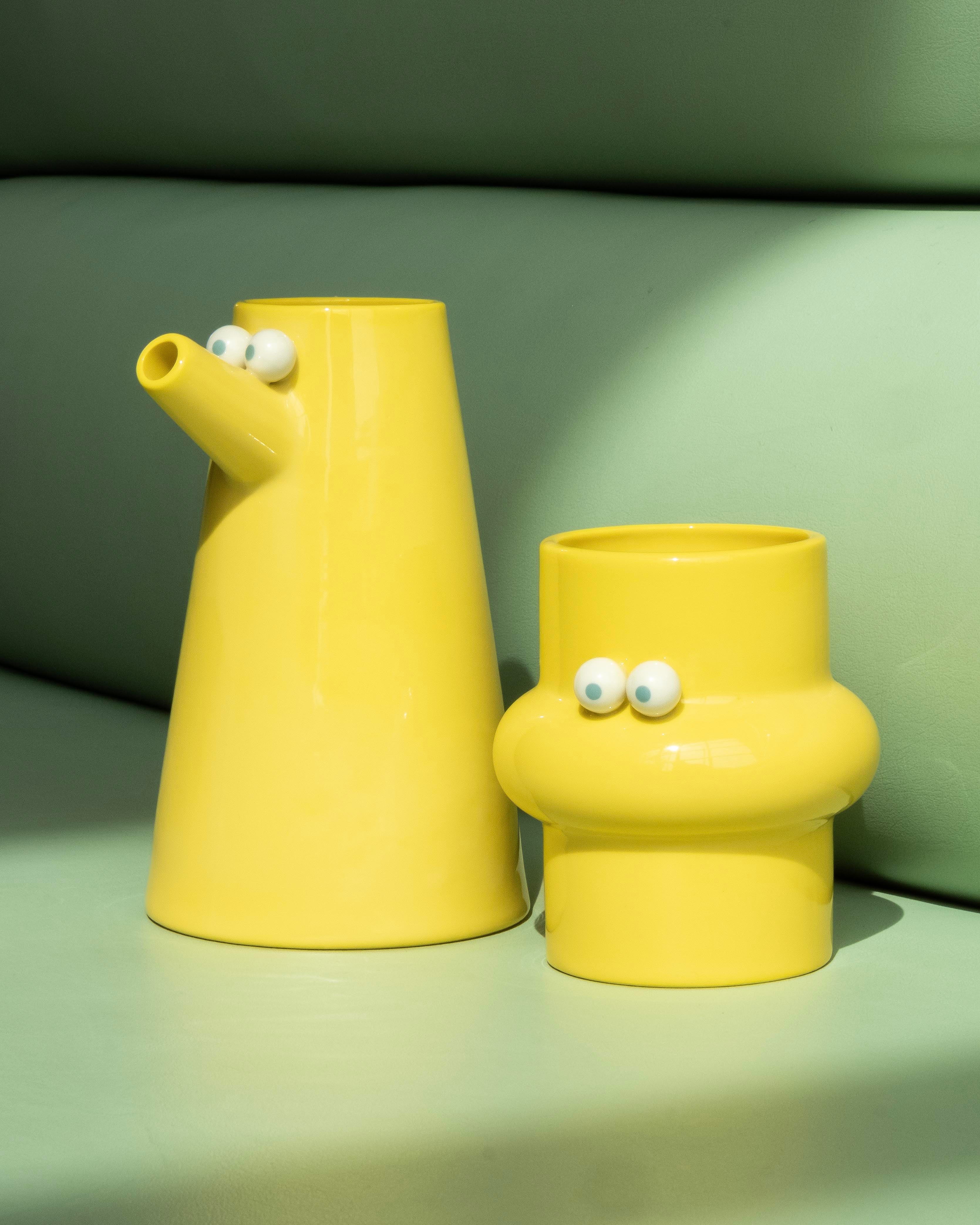 A Yellow Jug & Cupwith googly eyes on a green background, Lucas Zanotto