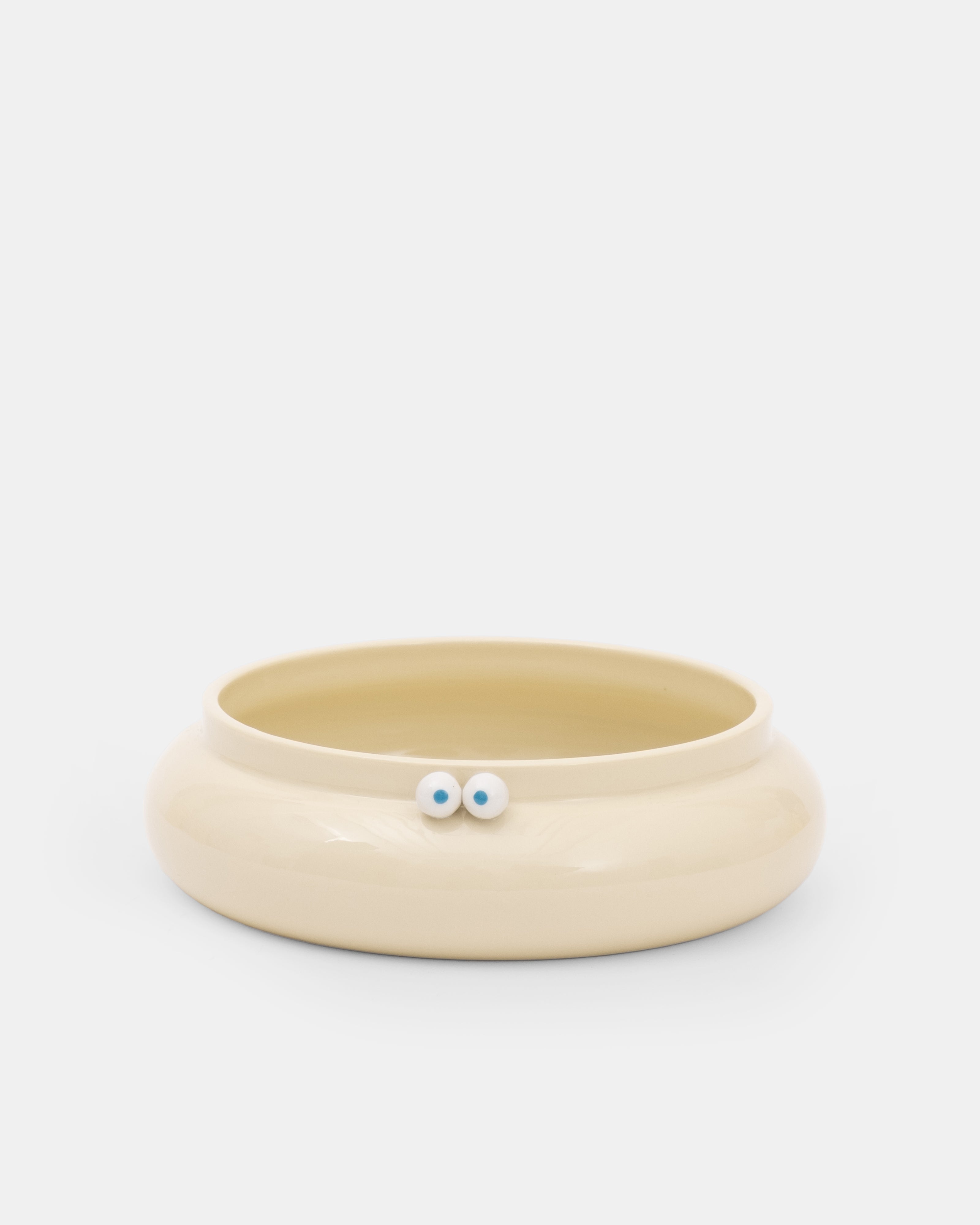 Beige ceramic bowl with small decorative elements on a white background