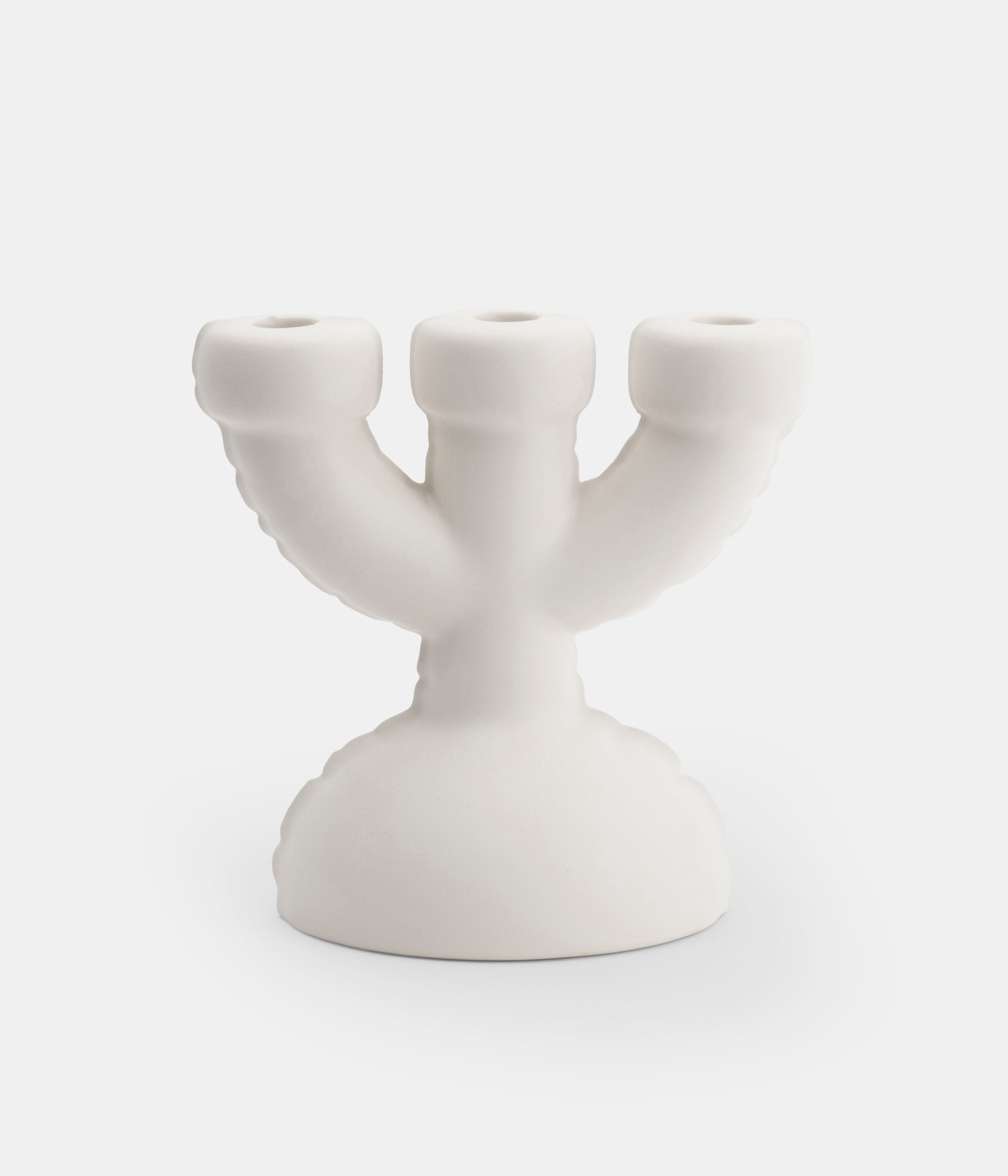 A white Home Studyo ceramic candelabra with a three-armed design, isolated on a white background.